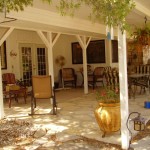 Cozy patio with comfortable seating and greenery under a covered pergola.
