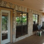 Stone wall patio with large windows and a door.