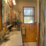 A rustic bathroom with wooden accents and a window.