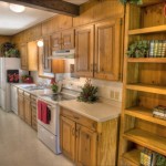 Cozy rustic kitchen with wooden cabinets and white appliances.