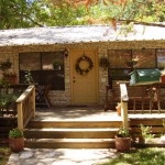 Cozy rustic cabin with wooden porch surrounded by nature.