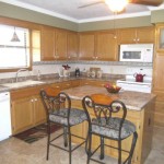 Cozy kitchen with wooden cabinets and breakfast bar seating.