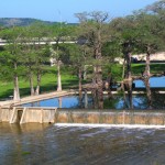 River with trees and a small dam.