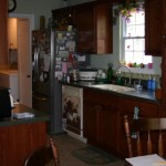 Cozy kitchen with wooden cabinets and stainless steel refrigerator.