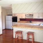 Bright kitchen with wooden stools and ample counter space.