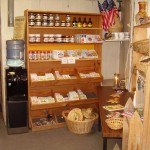 Interior of a small country store with shelves of goods and a water cooler.