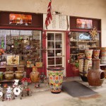Exterior of a rustic pottery and antique shop with colorful ceramic displays.