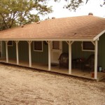 A rustic porch with green pillars and a brown roof.